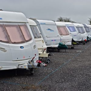 Caravans parked in a line at a caravan storage facility