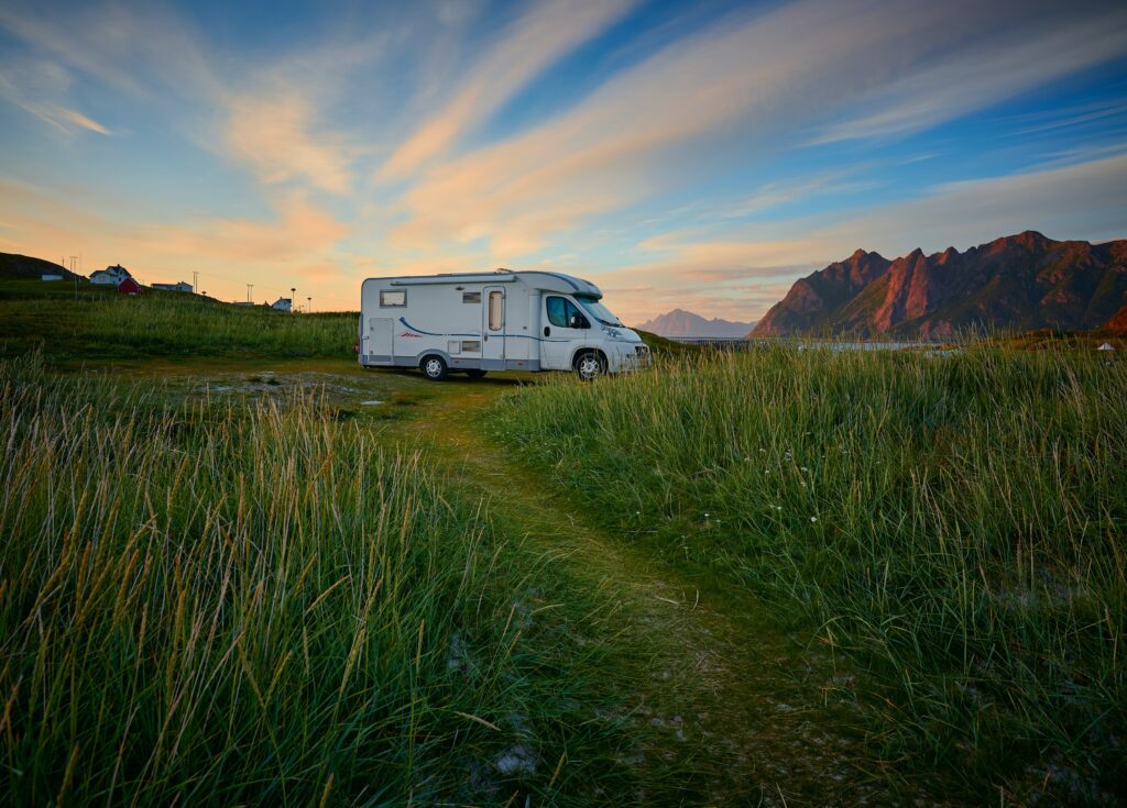 a motorhome in a field before sunset