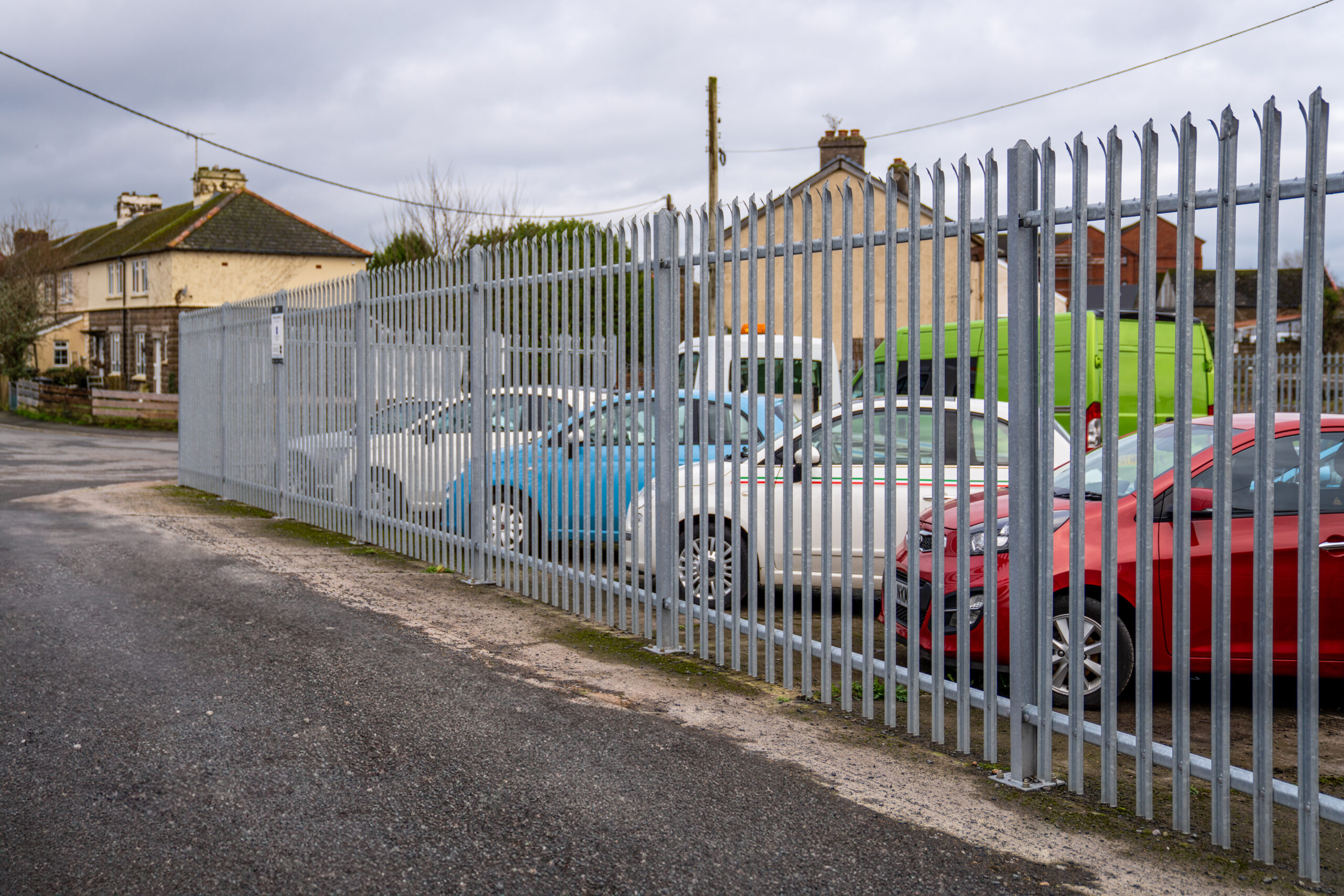 Cars behind a steel security fence at a vehicle and caravan storage facility in Barnstaple, North Devon